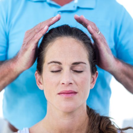 Therapist,Performing,Reiki,On,Young,Woman,At,Home